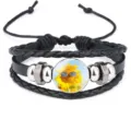 Detail view of a black braided leather bracelet featuring a cool sunflower charm - 18mm / Black