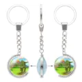 Silver rotating keychain featuring a cartoon Tyrannosaurus Rex in a prehistoric volcano scene - Rotating Keychain (Dinosaur) / #01