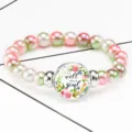 Macro detail of time gem charm on floral beaded elastic bracelet with soul quote - 12032502
