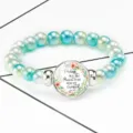 Close-up of pearl stretch bracelet with Bible quote Esther 4:14 in floral time gem pendant - 12032503