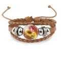 Close-up of brown leather bracelet with sunflower and butterfly glass cabochon design - 18mm / Brown