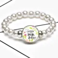 Close-up of stretch pearl bracelet featuring Strength & Dignity time gem pendant - 12032507