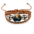 Macro view of a multilayered brown leather bracelet with a religious cross pendant. - Brown