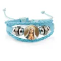 Detail view of a light blue braided leather bracelet with a Virgin Mary glass charm. - Blue