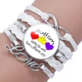 Close-up of white multi-layer braided Autism awareness bracelet with Love charm. - 12038604