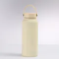 Close-up of minimalist matte cream insulated stainless steel water bottle with handle - Matte Off-White