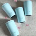 Vier hellblaue 12oz Edelstahl-Isolierbecher für Kaffee auf strukturiertem Hintergrund - 12oz / Blau