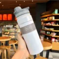 Handheld white 304 stainless steel vacuum insulated water bottle 530ml in a cafe. - 530ml / White