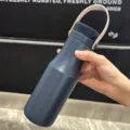 Close-up detail of a matte navy blue 304 stainless steel insulated bottle with strap - 470ML / Blue