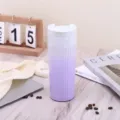 Detailansicht eines lila gestreiften Vakuum-Kaffeebechers aus Edelstahl auf dem Tisch - 500ml / Farbverlauf Lila
