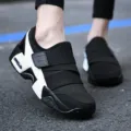 Vista dettagliata di scarpe da camminata in mesh traspirante nero e bianco con cinturino e suola. - 36 / Nero