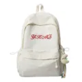 Detailansicht des lässigen weißen Canvas-Schulrucksacks mit roter Stickerei und Anhänger. - Ohne Anhänger / Weiß