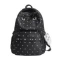 Vue détaillée du sac à dos à pois noir et blanc montrant la poche avant et le logo. - Noir