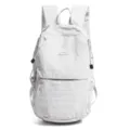 Detail shot of a white crinkled nylon outdoor backpack featuring a mountain logo - Light Gray