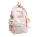 Detailansicht des rosa Batik-Rucksacks mit dekorativen Quasten und einem Plüschbär-Anhänger. - Rosa
