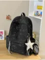Primer plano de mochila negra con estampado de estrellas y colgante de estrella de peluche. - Con Colgante / Negro