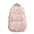 Detailed front view of pink school backpack featuring a red star pattern and multiple pockets - Pink