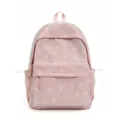 Gros plan d'un sac à dos d'écolier à carreaux roses avec broderie de nœud blanc - Rose