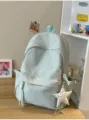 Primer plano de una mochila escolar azul menta con patrones de estrellas y llavero - Con Colgante / Azul