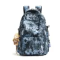 Front view detail of blue camouflage backpack with teddy bear charm and star prints. - Blue