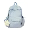 Vista detallada de mochila azul claro con estampado de corazones y llavero estrella - Azul