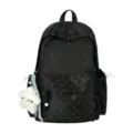 Detalle de mochila negra con lunares y un colgante de peluche de estrella blanca - Negro