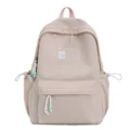 Gedetailleerd overzicht van beige schoolrugzak met LUONANI-patch en pastelkleurige kralenhangers - Roze