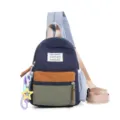 Detail of a color-block nylon student chest bag featuring a bear patch and star charm - With Charm / S / Dark Blue