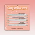 Close-up detail of the Capricorn themed ballpoint pen set, featuring fun quotes and pink card. - Capricorn / 5 Pcs Set