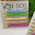 Set di 5 penne a sfera da ufficio divertenti e colorate con supporto in cartone per regalo. - Tema Il Lavoro Fa Schifo