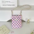 Detailweergave van roze crossbodytas met stippen en verstelbare schouderband met knoop - Roze blauwe stippen