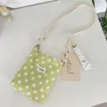 Detail van een groene crossbodytas met witte stippen en verstelbare schouderbanden van touw - Groene en Witte Stippen