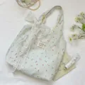 Détail du sac cabas à rayures fleuries orné d'un délicat nœud en dentelle blanche élégant. - Sac Fourre-tout Avec Nœud en Dentelle / Imprimé Floral Avec Fleur Blanche