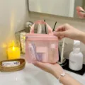 Detailansicht einer rosa Netz-Kulturtasche, die in einem modernen Bad gehalten wird - S / Rosa