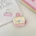Detailed view of a cute floral quilted earphone storage bag with snap button and pink ring - Light Pink