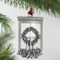 Detailed close-up of a silver window-shaped Christmas tree ornament with wreath and candles. - Window Wreath