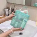 Detailansicht einer mintgrünen Netzwäschetasche mit Griff über einem Waschbecken gehalten - L / Grün