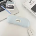 Close-up van een blauwe polkadot stoffen etui met een schattig geborduurd label. - Lichtblauw