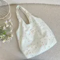 Vue détaillée d'un sac cabas vert clair à rayures fleuries avec une étiquette en tissu - Style Tote Bag / Gaze Florale Ensoleillée