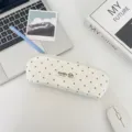 Detail van een schattig stoffen etui met stippen en een ritssluiting op een bureau - Beige