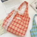 Dettaglio di una borsa shopping a quadri pesca con elegante fiocco in pizzo bianco su scrivania - Borsa Tote a Quadri (Fiocco di Pizzo) / Rosso