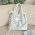 Detailed macro view of the delicate lace bow and marbled floral print on blue tote bag - Vest Bag With White Flower