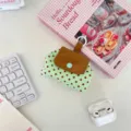 Detail view of a green polka dot storage pouch with snap button for headphones. - Green Polka Dot