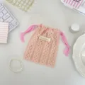 Detail view of an elegant peach lace drawstring storage bag for cosmetics and small items. - Pink