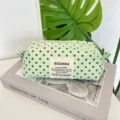Detailed view of a mint green polka dot canvas pouch with a fabric SOZAKKA brand label. - Green
