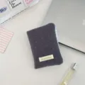 Dettaglio di un porta passaporto marrone a pois con eleganti finiture in quadretti blu - Piccoli pois in lana grigio
