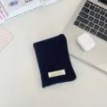 Vista dettagliata del porta passaporto in peluche blu navy con bordi a quadretti blu - Piccoli pois in lana blu marina