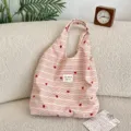 Macro detail of the heart embroidery on a pink and white striped tote bag fabric - Red Heart Stripe