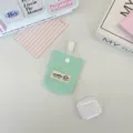 Close-up of a mint green quilted earphone pouch with a brand label and snap button - Light Green