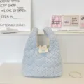 Gros plan d'un sac à main bleu clair matelassé en forme de cœur avec pois et bouton cœur - Cœur Matelassé à Pois Bleu Clair